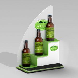 A custom white and green tiered back bar display with "bath ales wild hare" bottles on display.