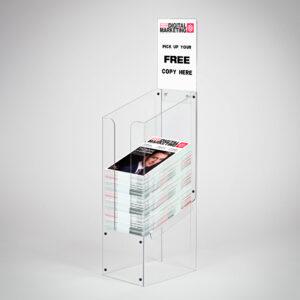A clear acrylic dump bin with a header holding magazines.