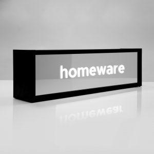 Mirror faced lightbox with illuminated white text, premium retail signage display with black frame.