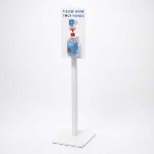 A freestanding hand sanister unit with header graphics and soap, facing the corner.