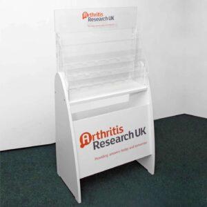 A health care information display with custom "arthritis research UK" branding on the front and header.
