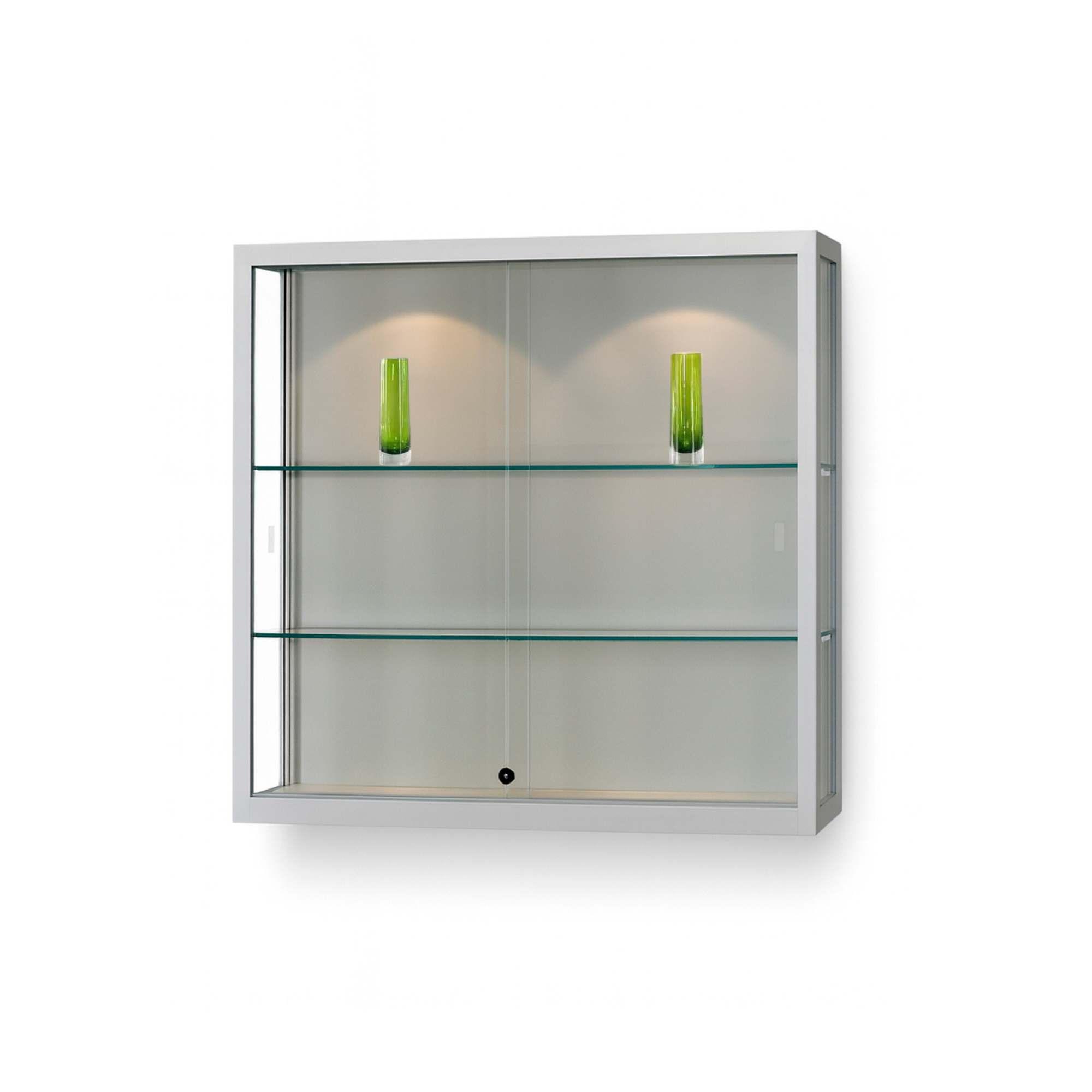 A silver wall mounted cabinet with spotlights and green glasses on display.