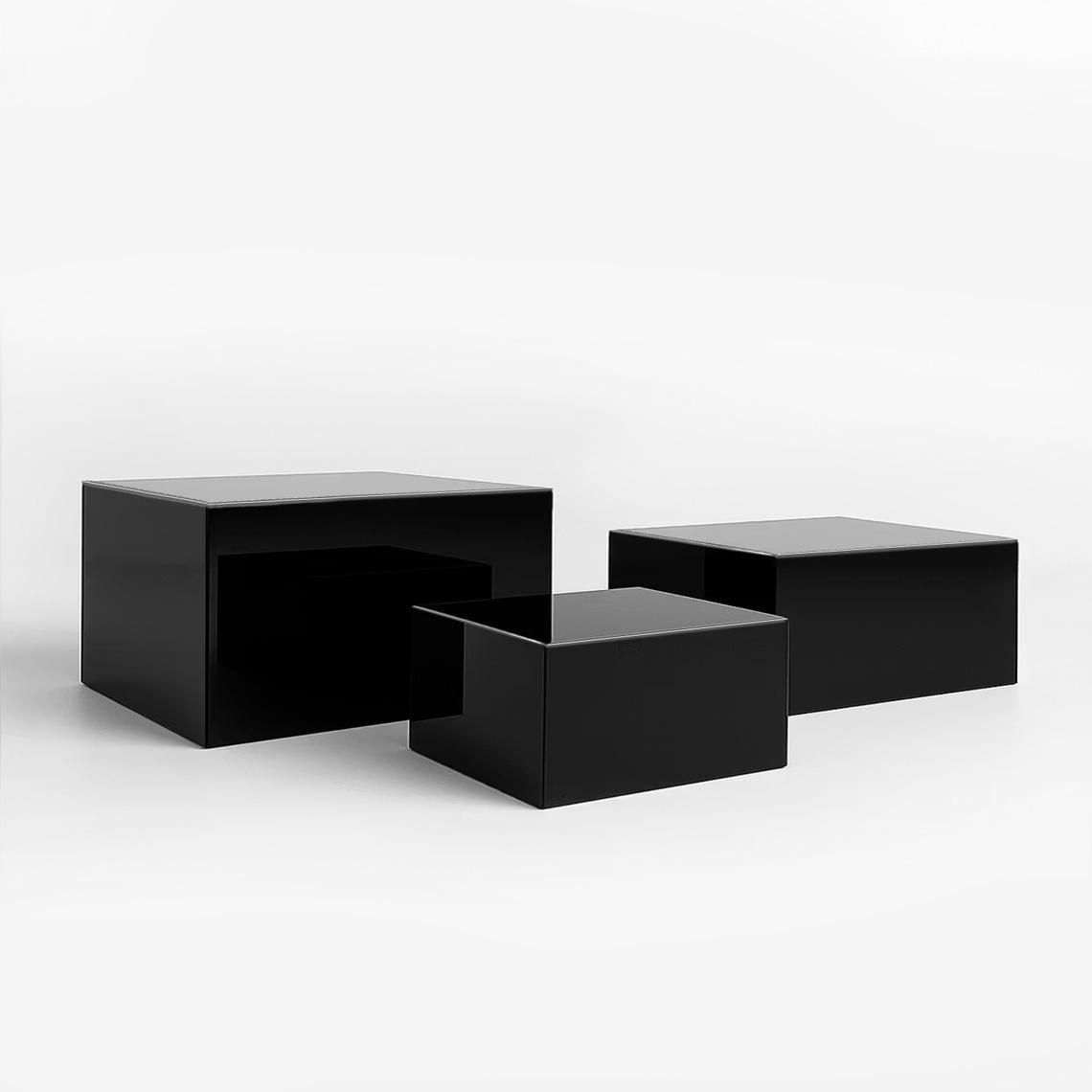 Three black gloss acrylic display plinths with reflective surfaces, used for premium retail product displays.