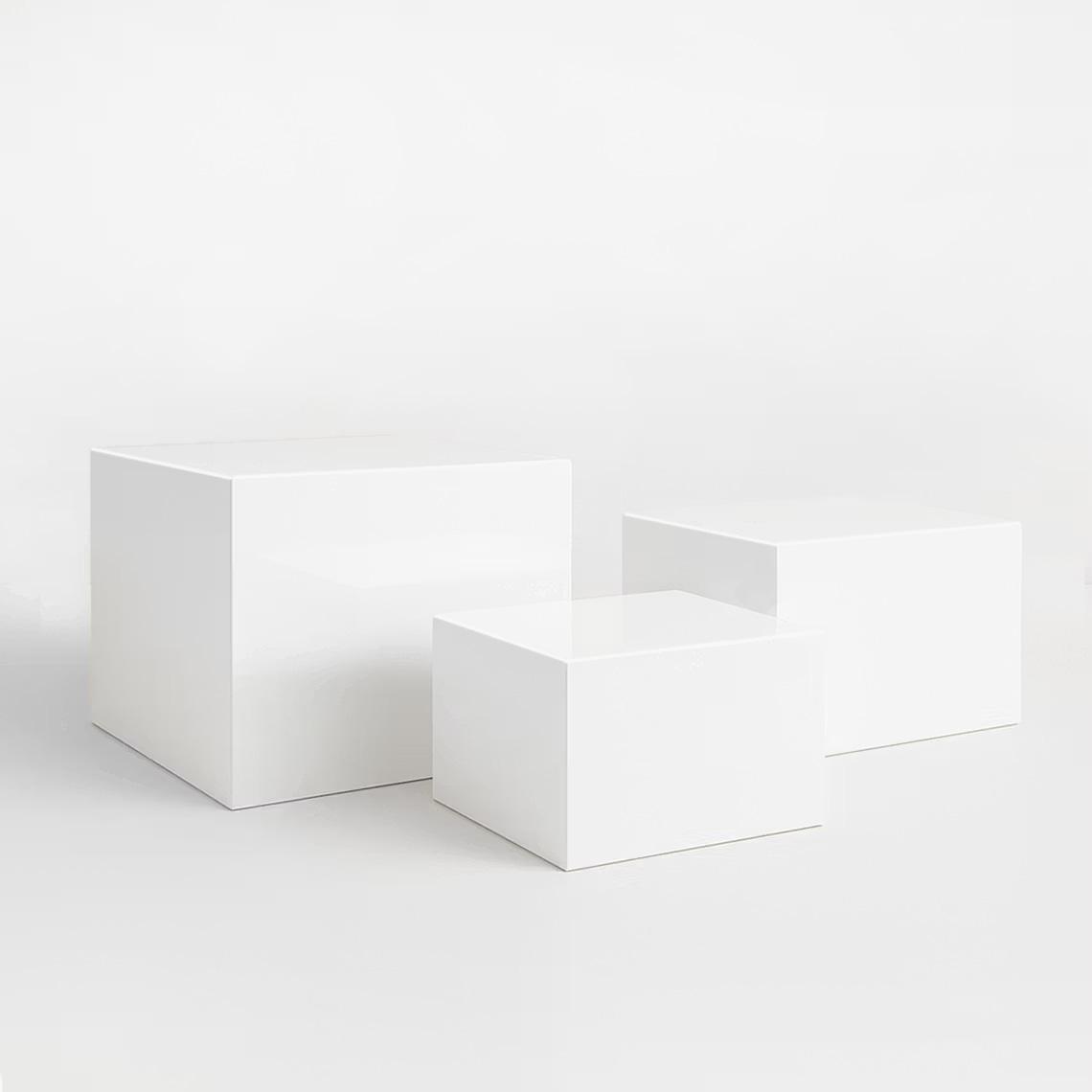 Set of three white gloss acrylic plinths with reflective finish, perfect for modern retail and exhibition displays.
