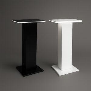 Two modern illuminated display plinths, one black and one white, standing on a dark background with glowing edges highlighting the capped top design.