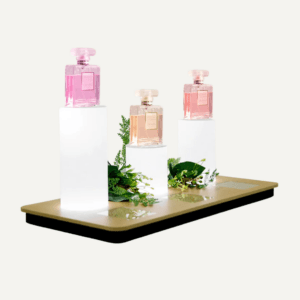An illuminated product showcase plinth with jimmy choo perfume bottles on display.