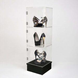 A stacking acrylic cube display with three cubes, a black base and some high heels on display.
