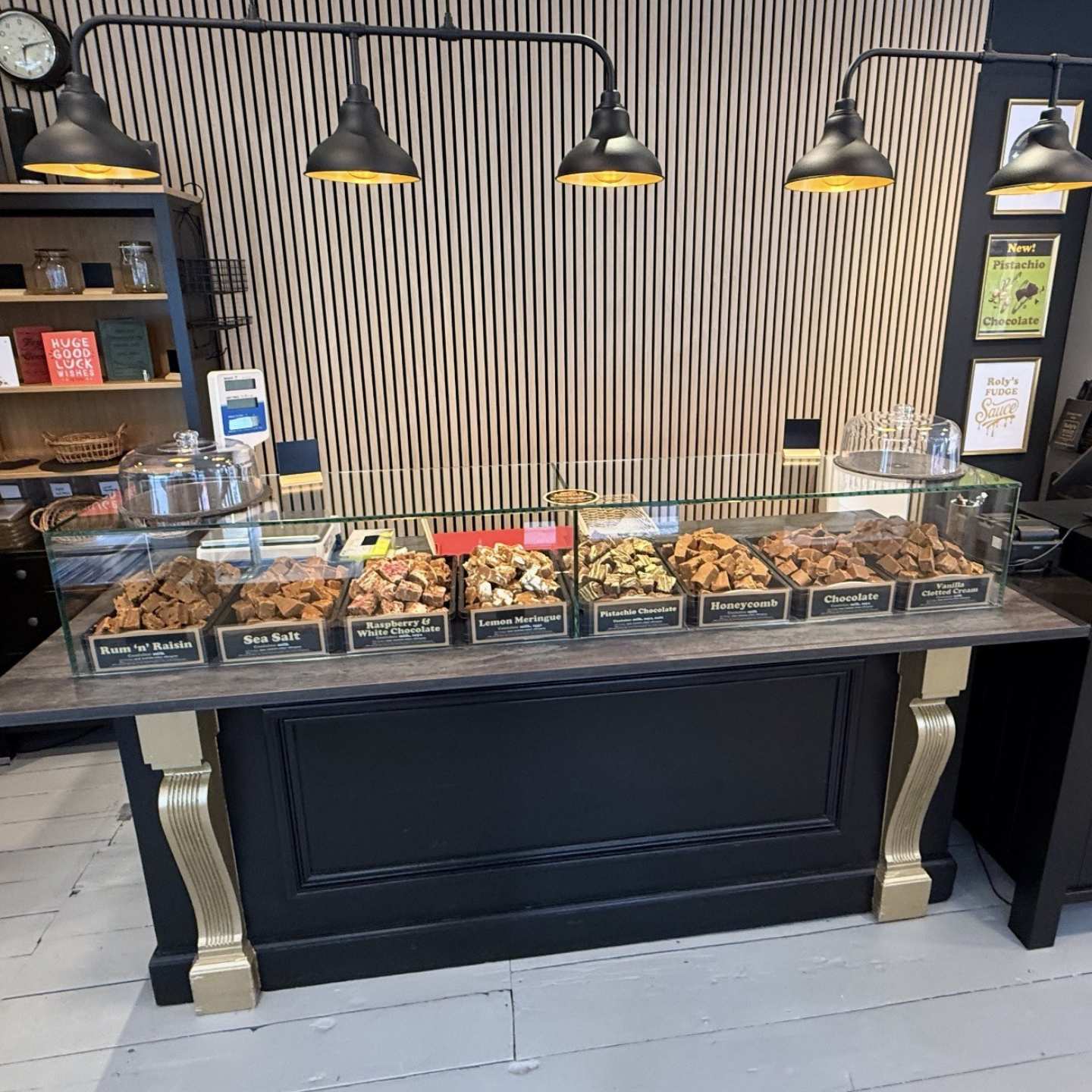 A bespoke glass sneeze guard on a tabletop with fudge on display.