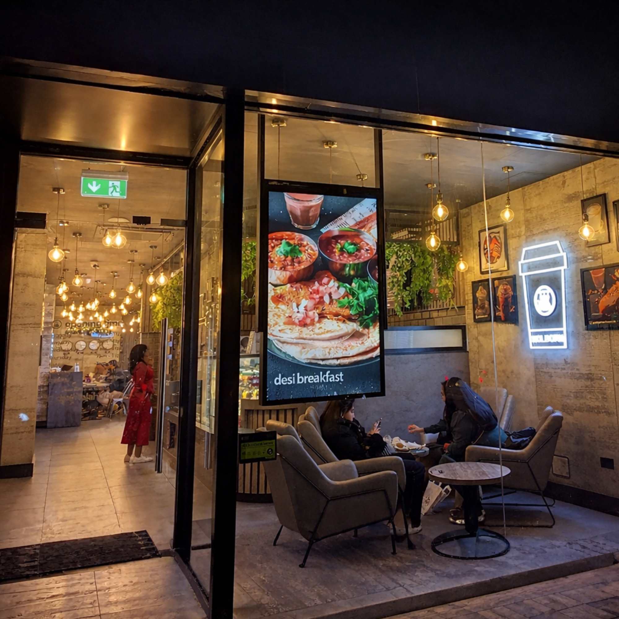 A ceiling hanging ultra-high-brightness double sided advertising screen in black in the front of a shop window.