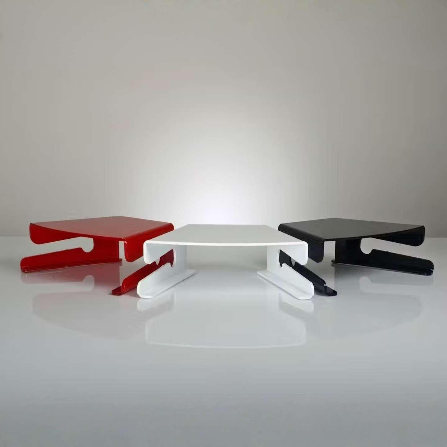 Three acrylic monitor stands in white, red and black.