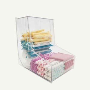 A clear acrylic period product pick and mix dispenser with tampons and pads inside.