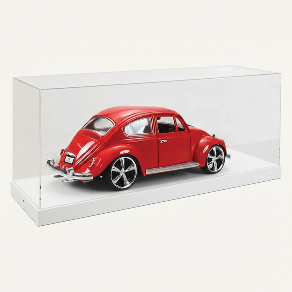 A model display case with a white base and a clear acrylic lid with a red car on display.