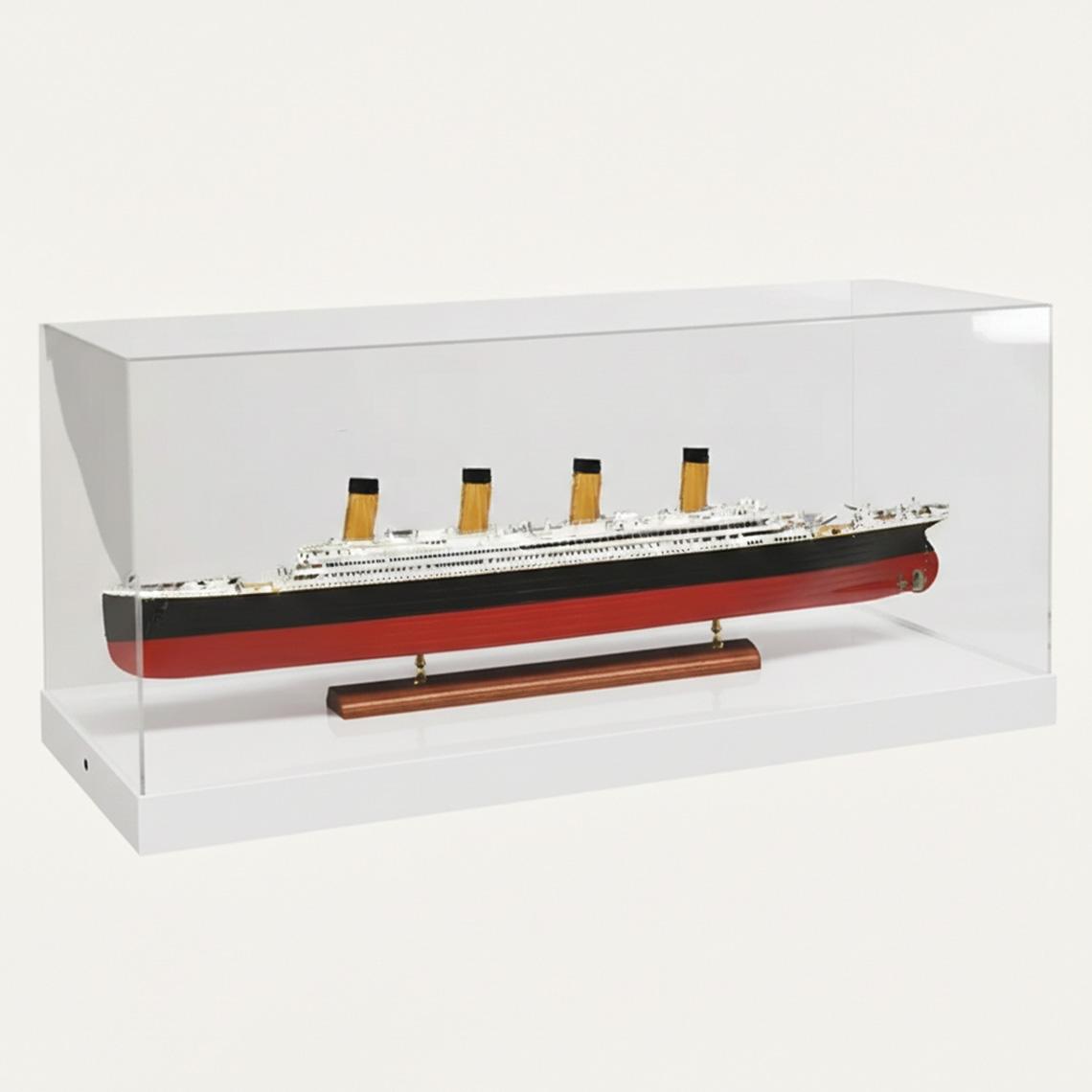 A model display case with a white base, a clear acrylic lid and a model boat on display.