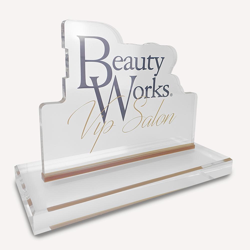 A solid clear acrylic, custom made award with "beauty works" logo on the front.