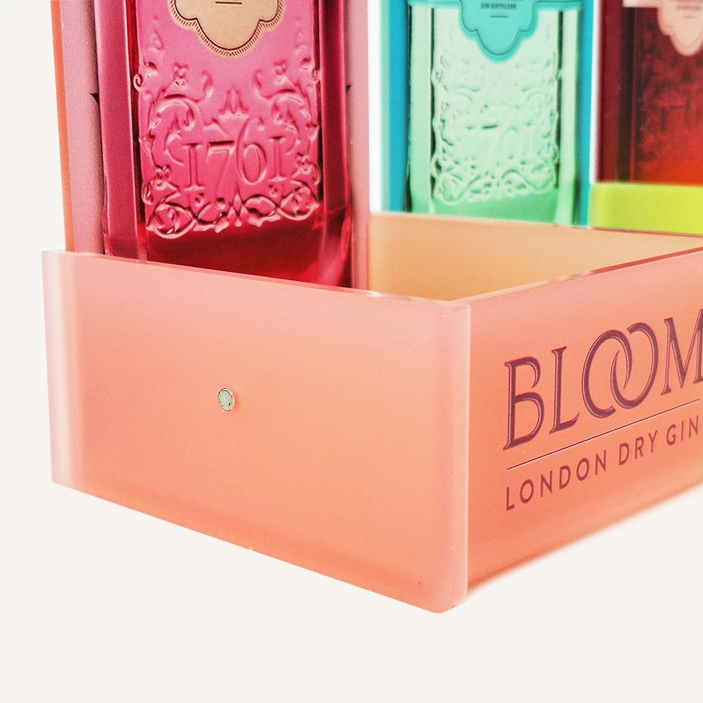 A close up of a small magnet on the side of a Bloom gin bottle point of sale display box.