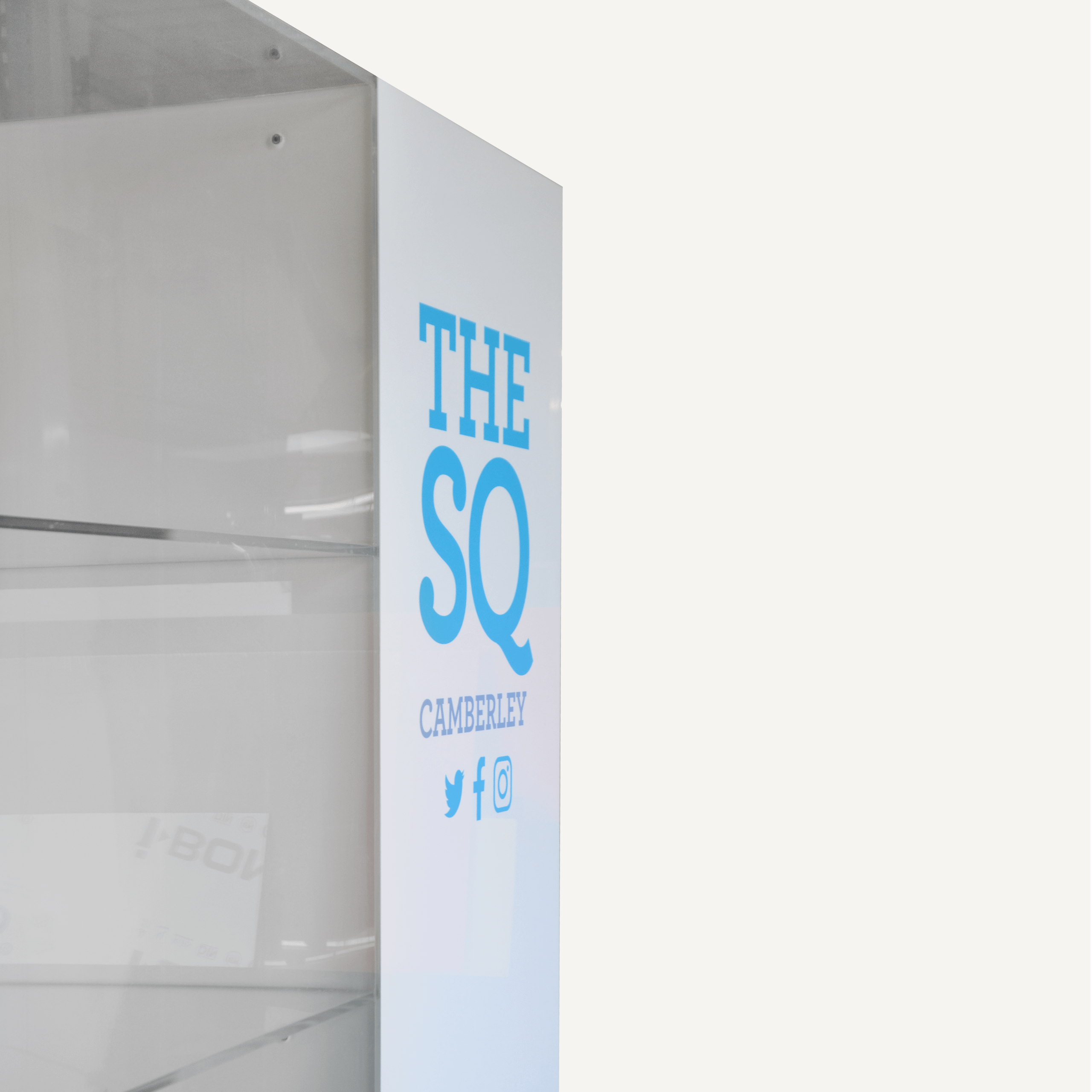 Close up of an acrylic custom display cabinet with The SQ Camberley logo and branding.