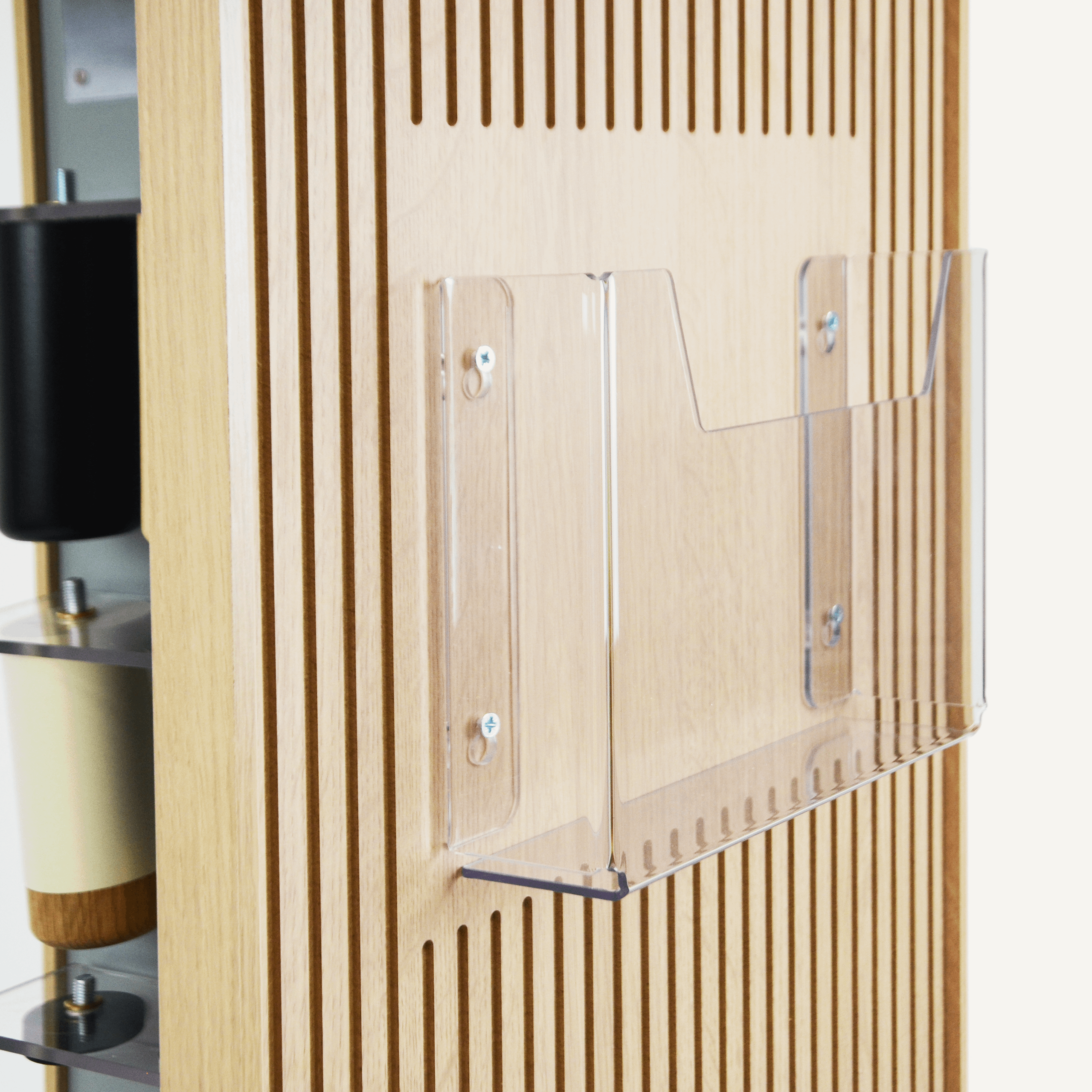 A close up of an acrylic brochure holder on a plywood rotating POS display.