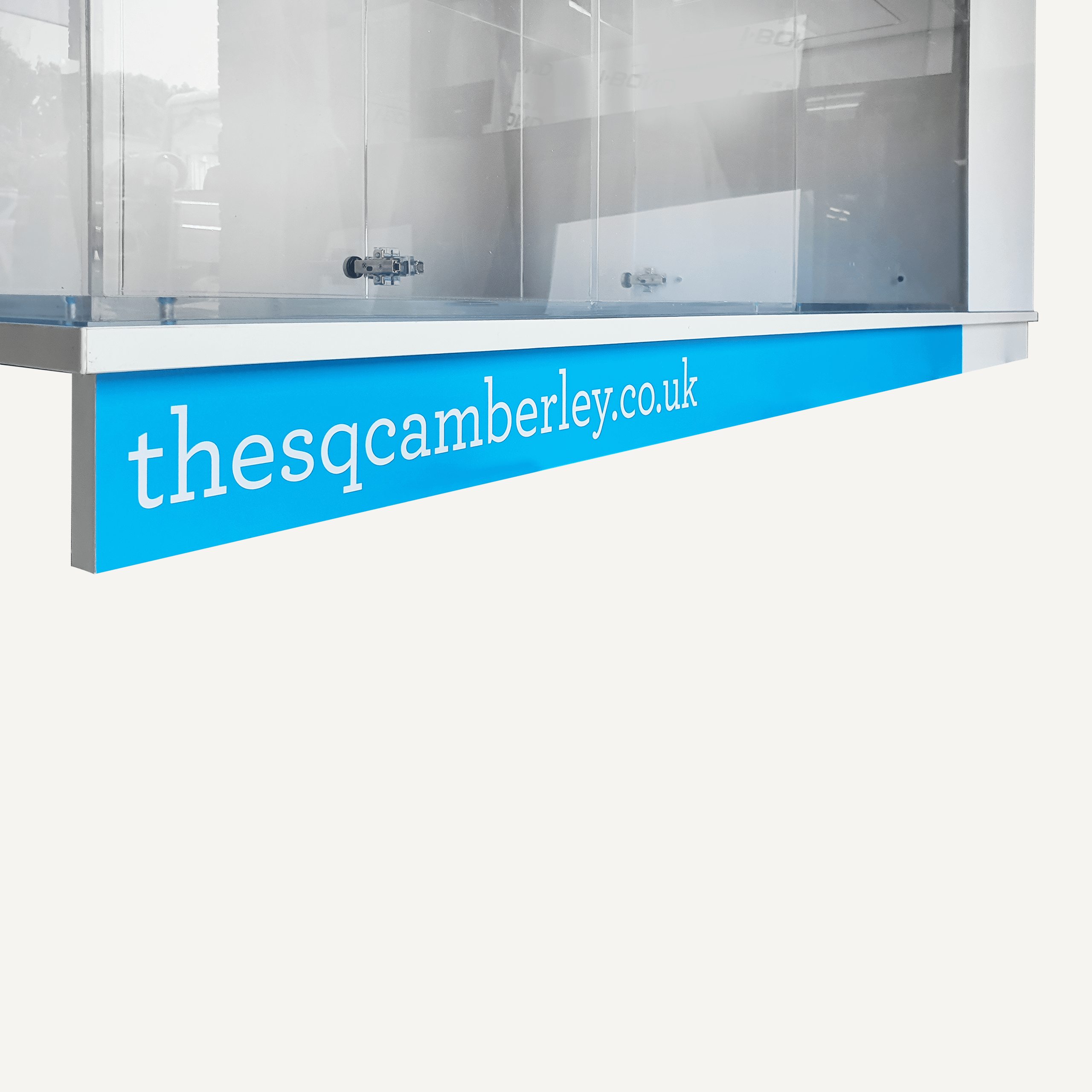 A close up of The SQ Camberley's website on a blue base panel of an acrylic custom display cabinet.
