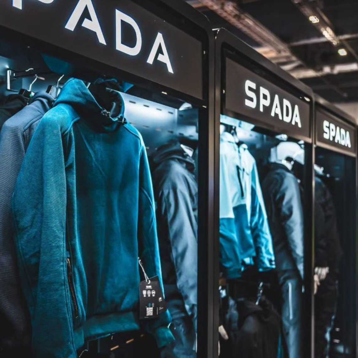 A close up of a Feridax Spada exhibition retail display, showcasing clothing under lighting.