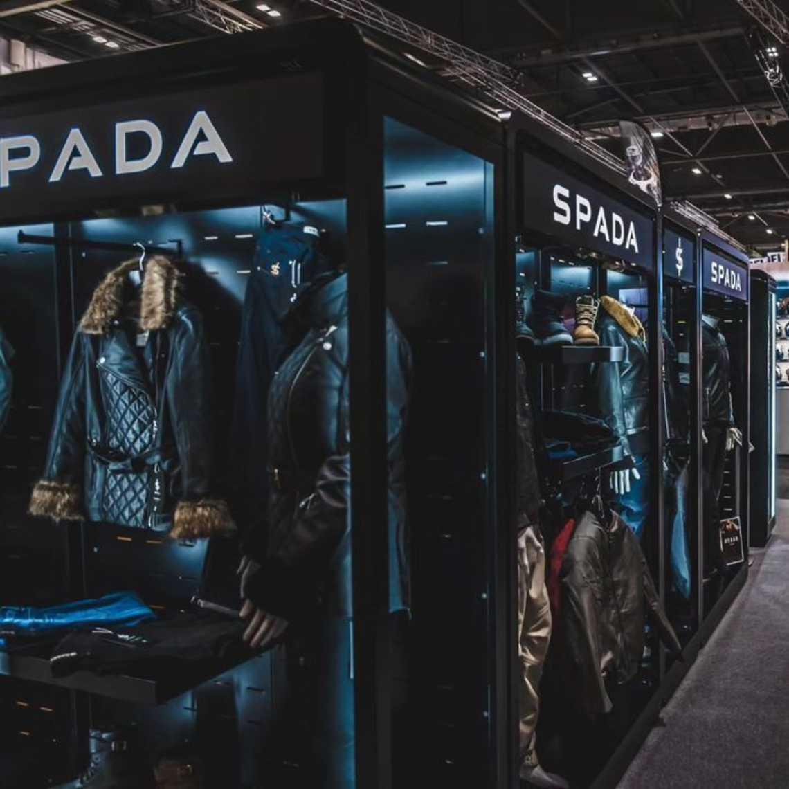 A close up corner angle of a Feridax Spada exhibition retail display, showcasing mannequins, clothing and shoes under lighting.