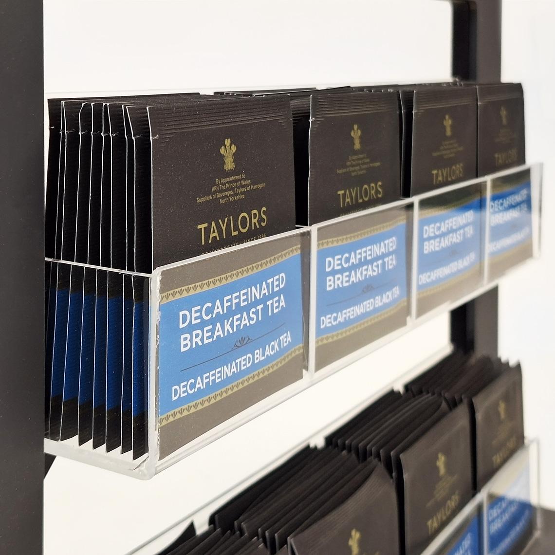 A close up of a black Taylors of Harrogate tea bag pos display with clear acrylic tea bag holders.