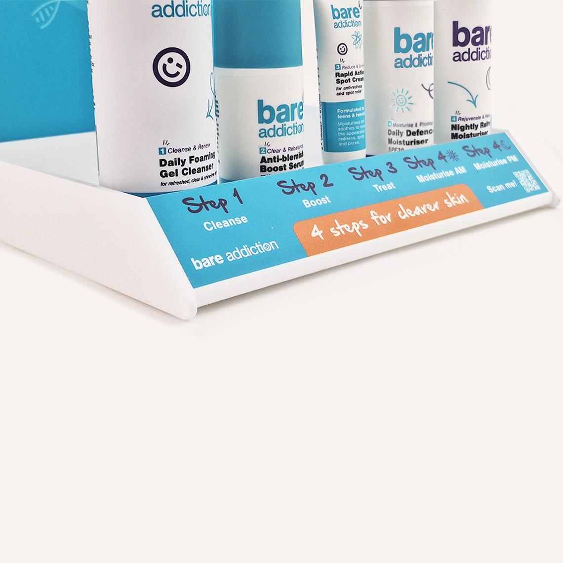 A close up of a Bare Addiction branded product glorifier with custom messaging and skincare products sat in the display.