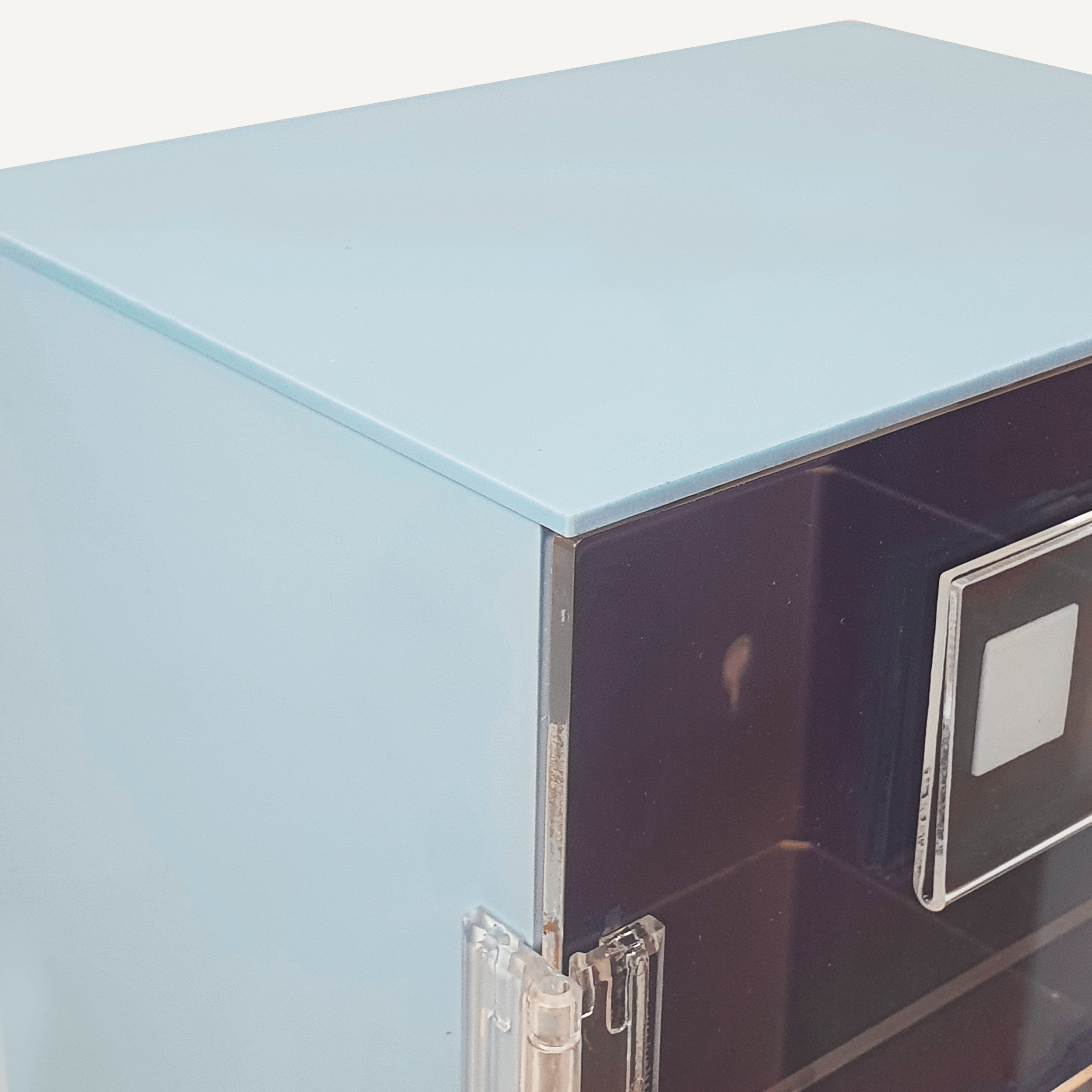 A close up of a the corner of a blue and clear acrylic PPE storage cabinet.