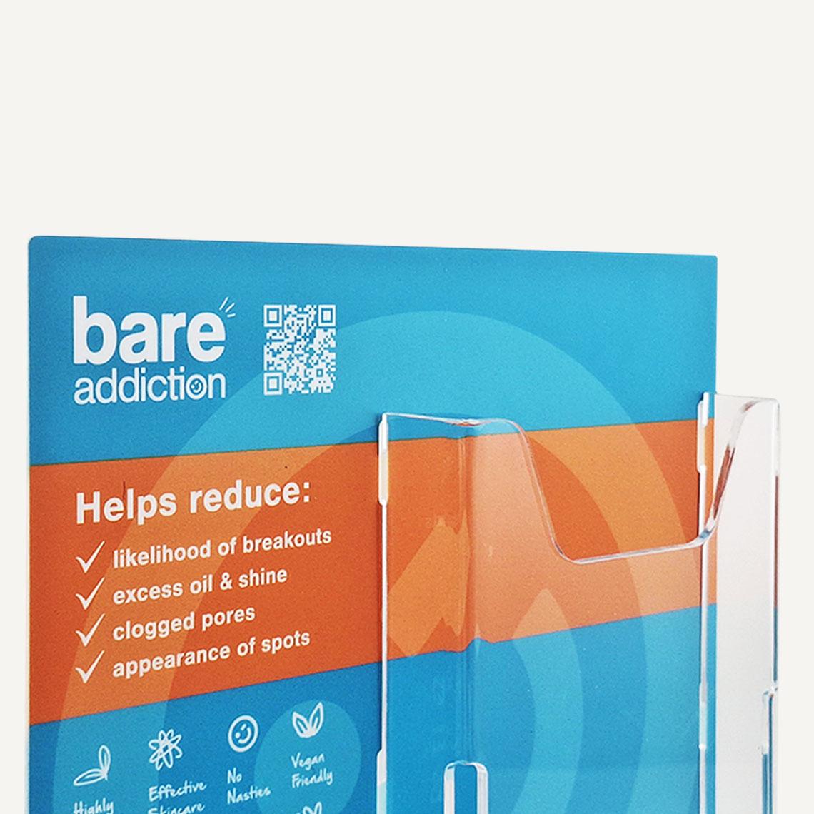 A close up of a Bare Addiction branded product glorifier with custom messaging and an acrylic brochure compartment on the display.