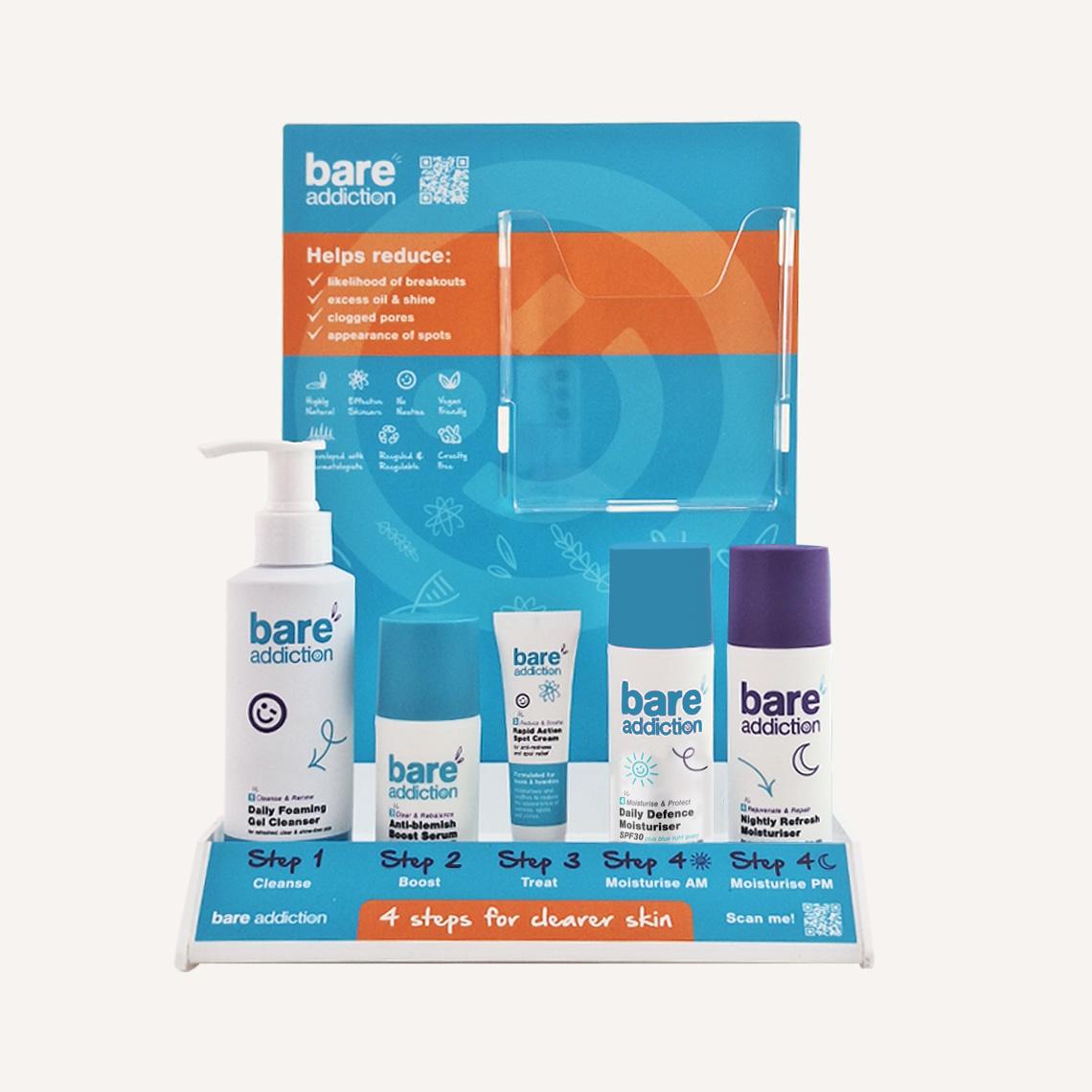 Front facing Bare Addiction branded product glorifier with custom messaging and skincare products sat in the display. There is an acrylic brochure compartment on the display.