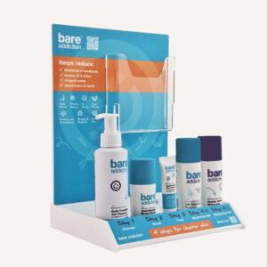 A Bare Addiction branded product glorifier with custom messaging and skincare products sat in the display. There is an acrylic brochure compartment on the display.