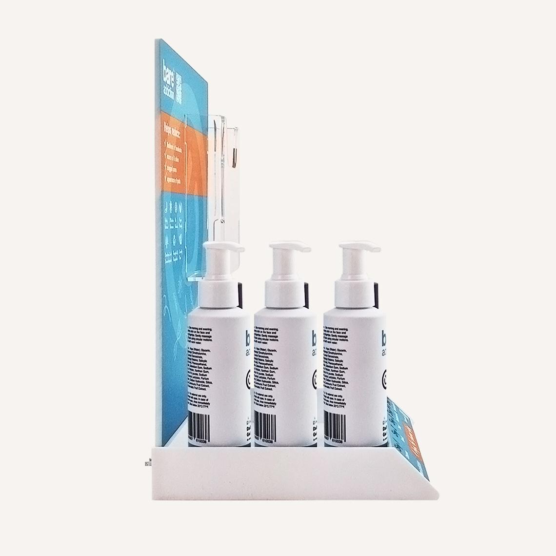 Side view of a Bare Addiction branded product glorifier with custom messaging and skincare products sat in the display. There is an acrylic brochure compartment on the display.