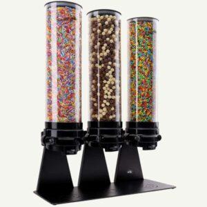 A black and clear three cylinder candy dispenser filled with different types of colourful sweets.