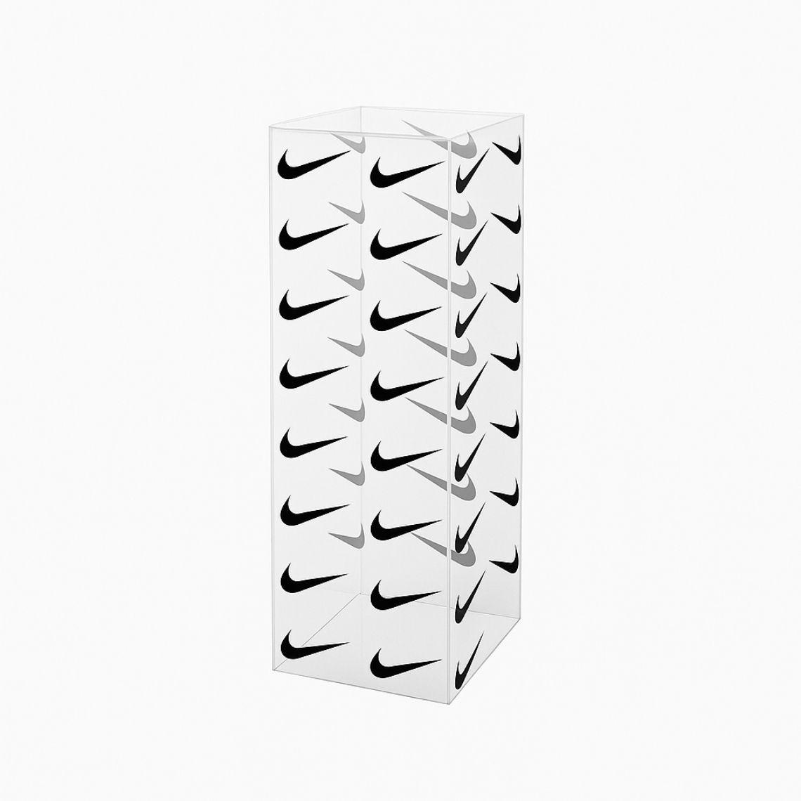 Clear acrylic display plinth with a transparent design, decorated on all four sides with a repeating abstract black logo pattern, photographed against a plain white background to highlight its modern, branded aesthetic.
