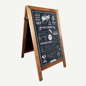A wood finish A-board chalkboard with Menu drawn in white chalk pen.