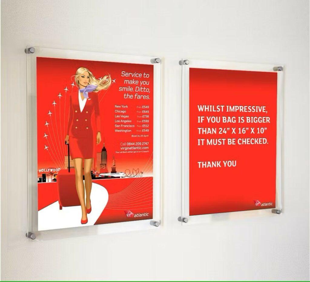 A virgin atlantic advertisement in two clear acrylic frames.
