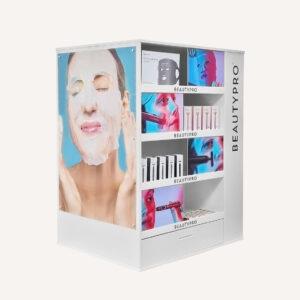 White branded floor standing display unit with beauty pro beauty products on display. Featuring four shelves, a storage draw at the bottom and digitally printed graphics.