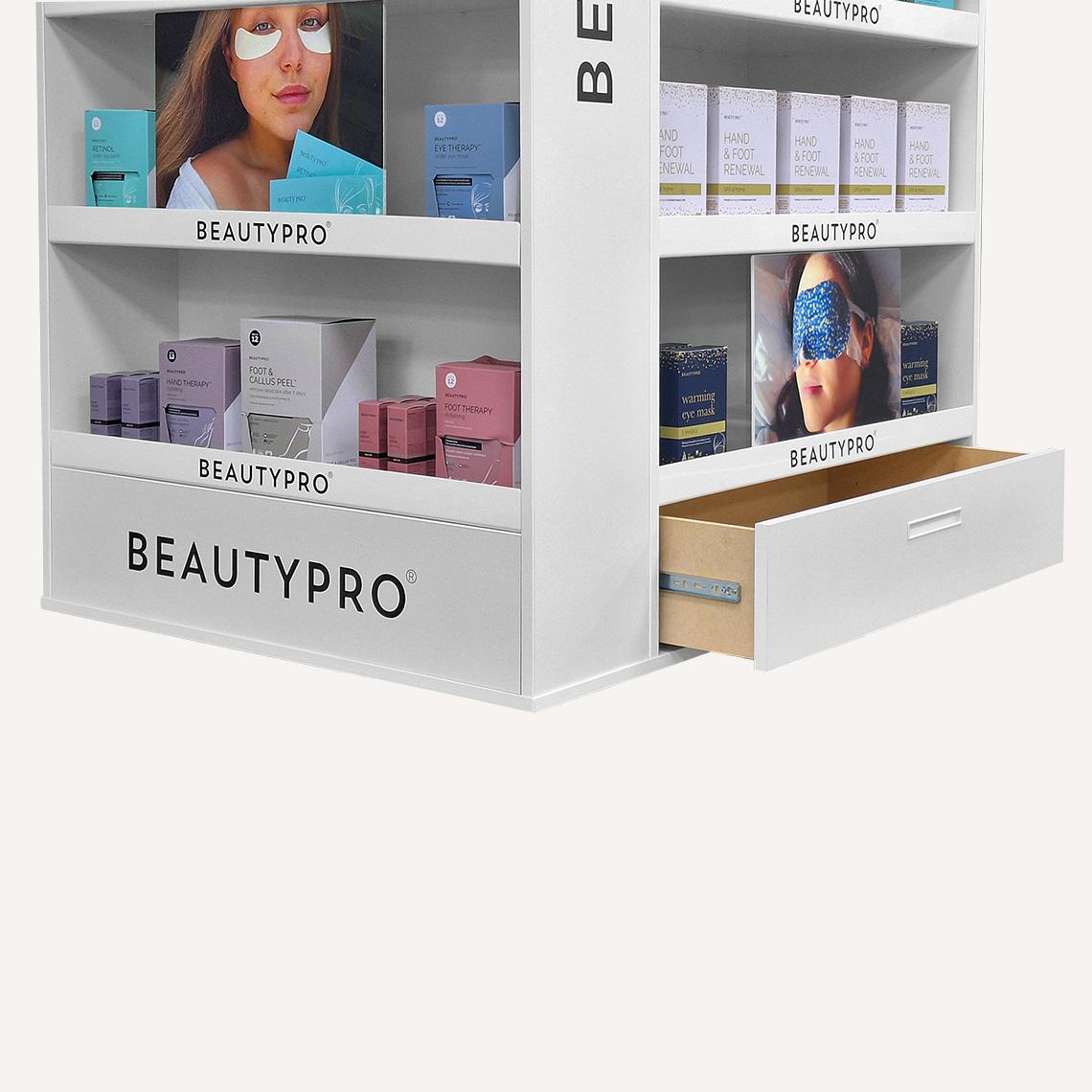 Close up of the bottom storage draw open on the white branded floor standing display unit with beauty pro beauty products on display.