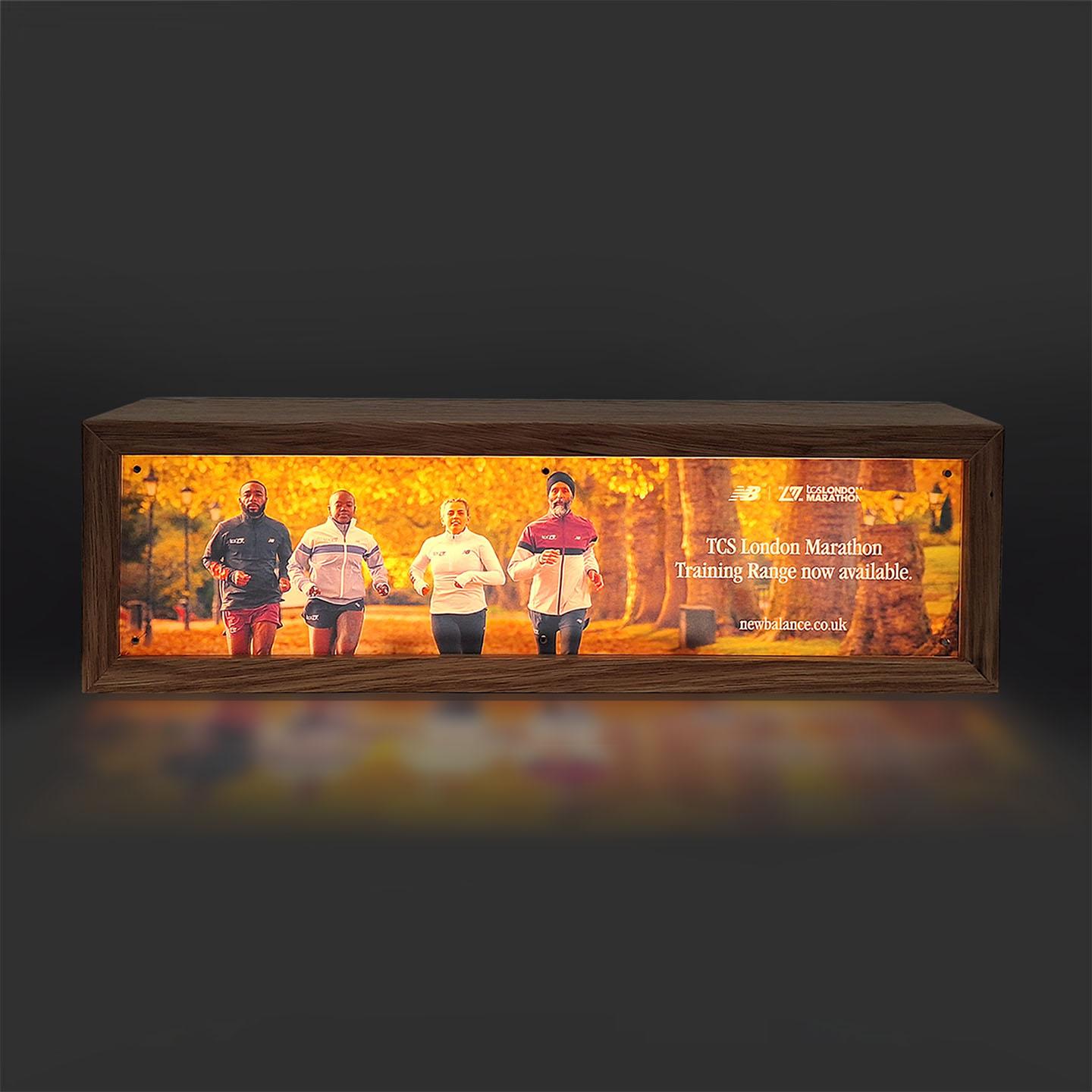 Illuminated Wooden Lightbox with Custom branding for New Balance facing the front.