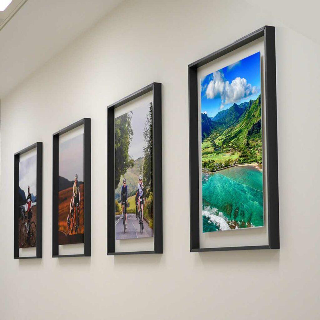 A set of 4 black frames with prints inside.