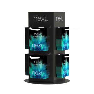 A custom"next" rotating countertop display holding gift cards.