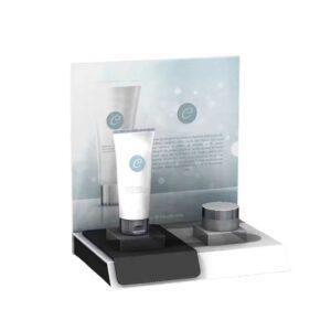 A countertop display with printed header graphics holding skincare products.