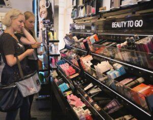 A woman and a girl shopping and looking at beauty to go products.