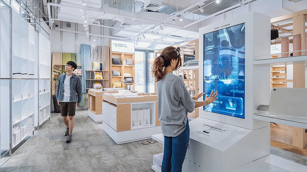 A woman browsing a digital screen in a shop.