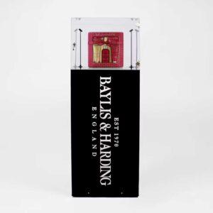 A branded, illuminated plinth with a lock and products on display.
