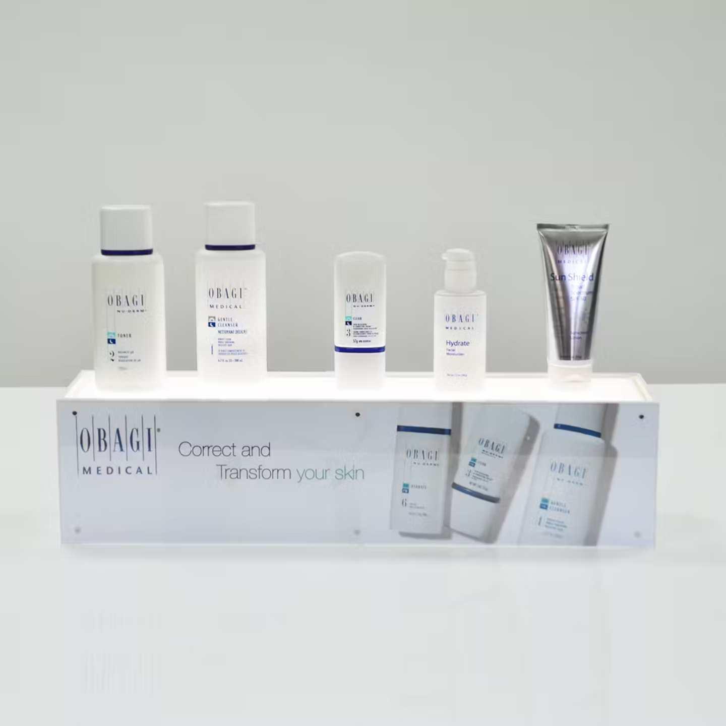 An illuminated countertop plinth with skincare products on top.