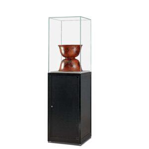 A black display plinth with protective cover and red vase.