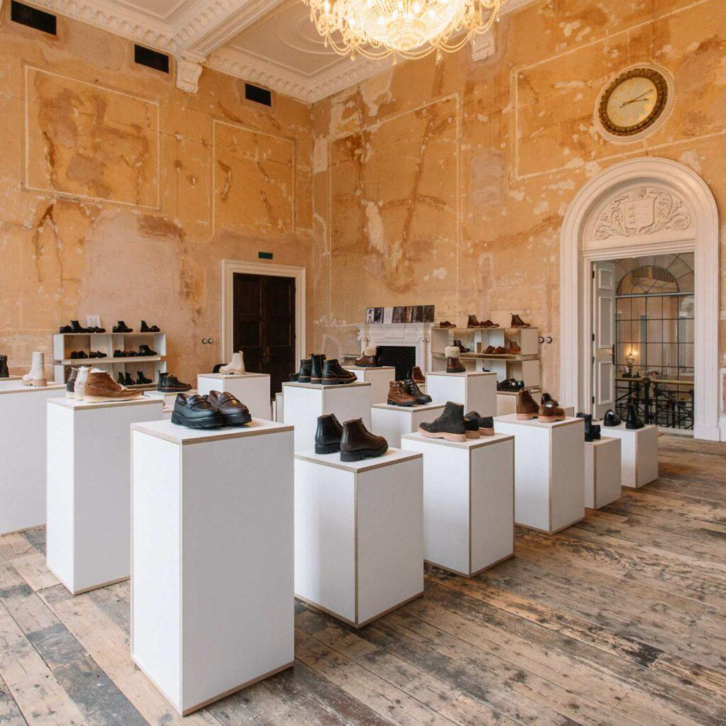 A room filled with white display plinths with products on top.