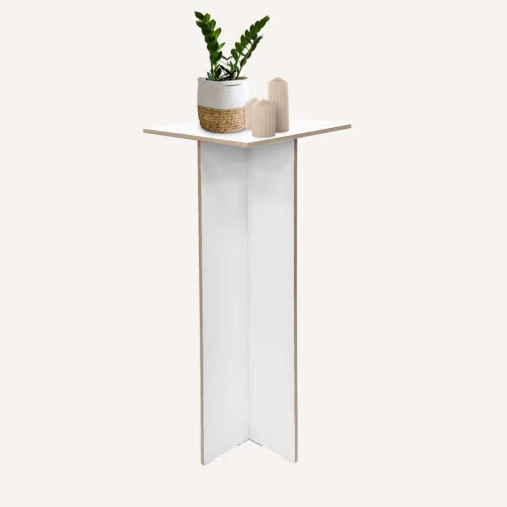 A white plinth pedestal with a decorative plant on top.
