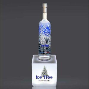 An illuminated countertop bottle plinth with vodka sat on top.