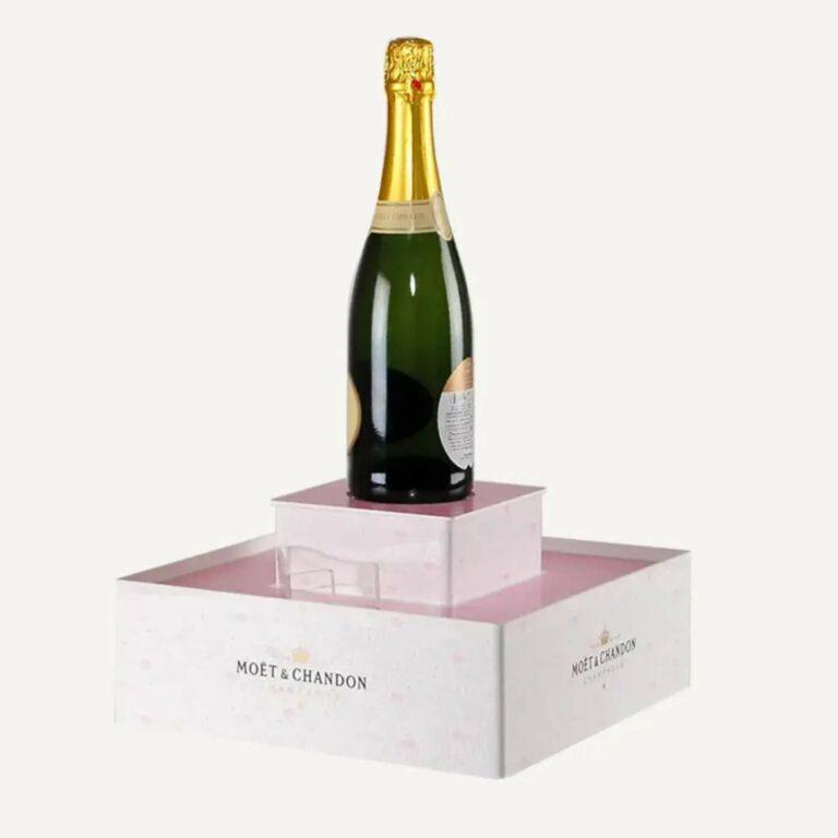 A portable pink, custom plinth with a bottle on top.